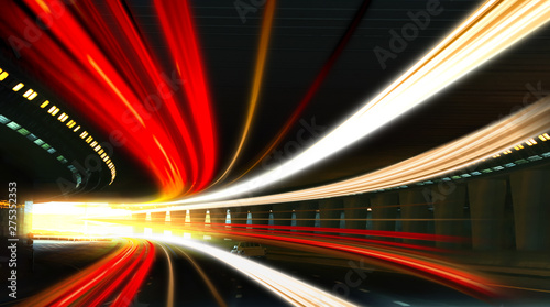 Modern cars driving through illuminated highway tunnel