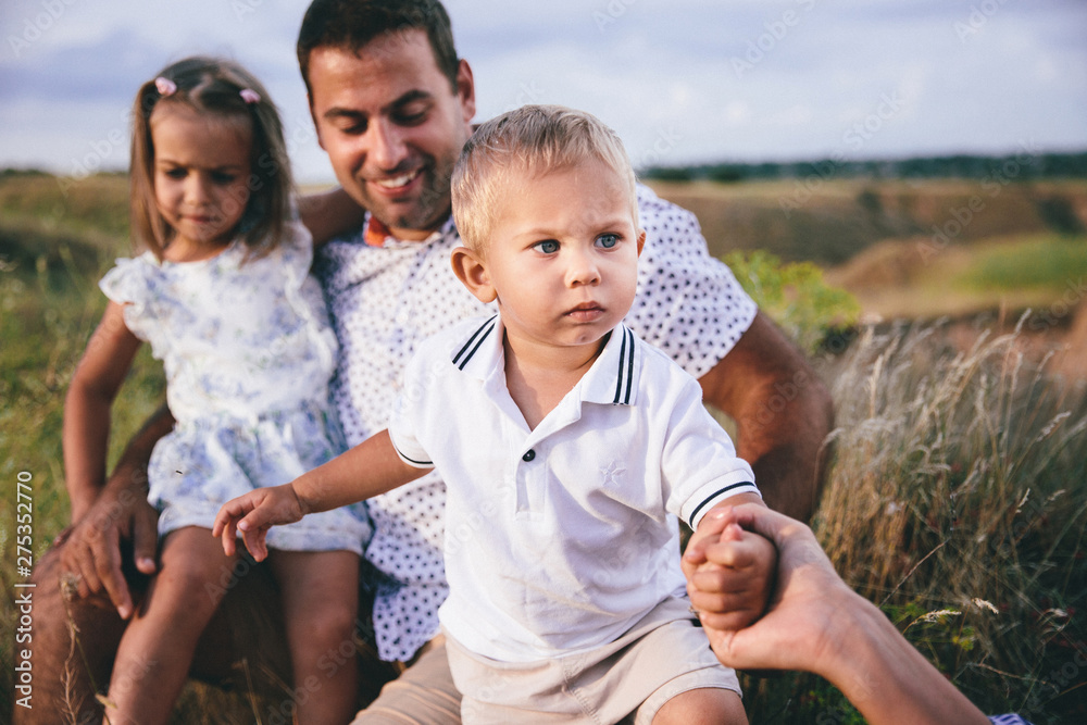 Happy dad and children having fun outdoors in a wheat field. Happy dad and children having fun outdoors in a wheat field.