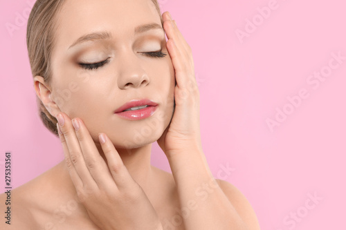 Portrait of young woman with beautiful face on pink background, closeup. Space for text