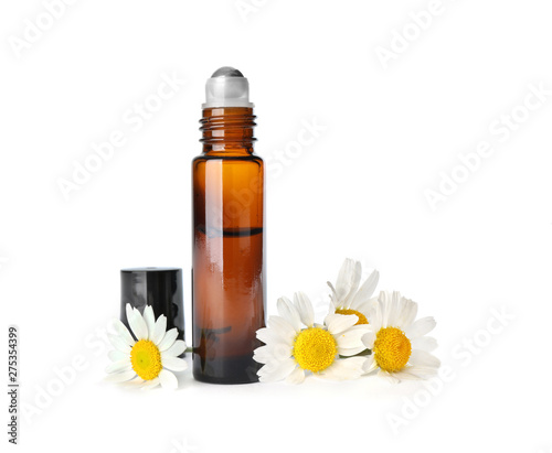 Bottle of herbal essential oil and chamomile flowers isolated on white