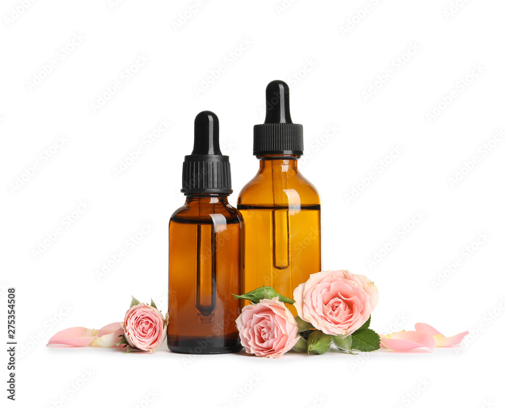 Bottles of rose essential oil and flowers isolated on white Bottles of rose essential oil and flowers isolated on white