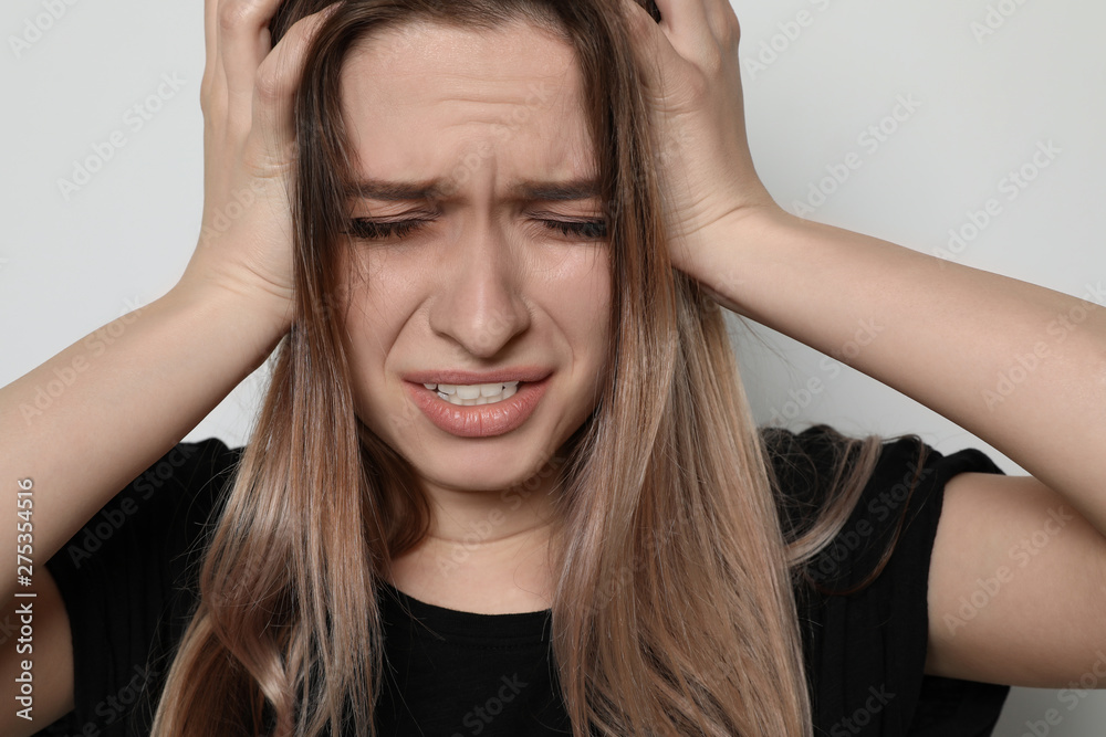 Desperate young woman on light background. Stop violence Desperate young woman on light background. Stop violence