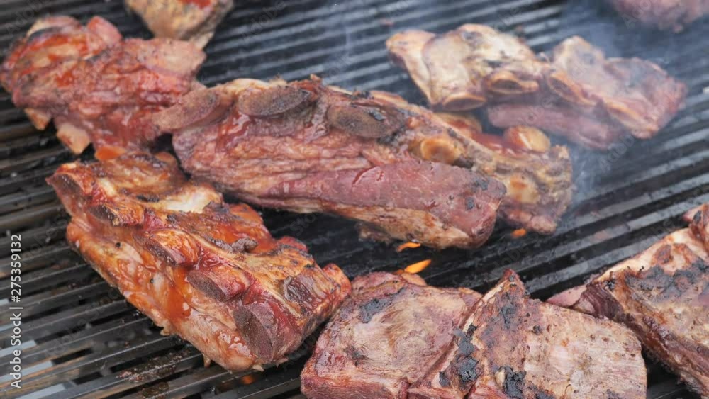 American Barbecue, Frying Fresh Meat, Chicken Barbecue,Pork, Ribs, Kebab, Hamburger, BBQ,Josper, Beef. Sunny outdoor.Chef turns the meat on the rotating Grill Slow motion 4k Top viev Clous-up American Barbecue, Frying Fresh Meat, Chicken Barbecue,Pork, Ribs, Kebab, Hamburger, BBQ,Josper, Beef. Sunny outdoor.Chef turns the meat on the rotating Grill Slow motion 4k Top viev Clous-up
