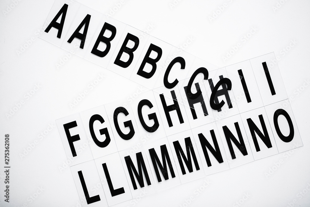 Black capitalize letter on white table background. Black capitalize letter on white table background.