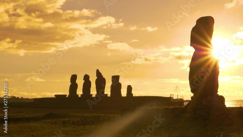 SILHOUETTE, LENS FLARE, COPY SPACE: Scenic view of ancient moai sculptures on the shore of Easter Island on a sunny summer evening. Scenic view of historic archaeological site of Ahu Tahai at sunset. photo