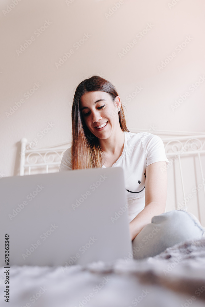 beautiful feminist woman smiling and writing on her laptop beautiful feminist woman smiling and writing on her laptop