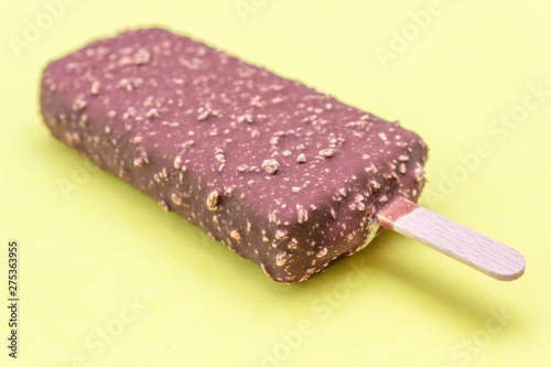 Chocolate ice cream with nuts, isolated on a yellow background.