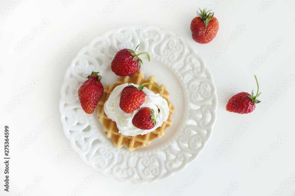 Waffle with Cream and Strawberries in a White Plate isolated on a White Background Waffle with Cream and Strawberries in a White Plate isolated on a White Background