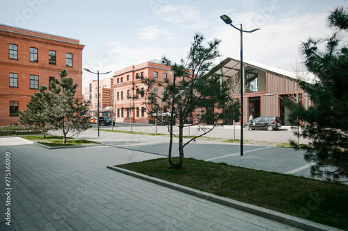 Decorative lighting pole in cityscape. Modern loft building from red brick in downtown area. Manufacture Arma in Moscow. Industrial design in city architecture. Business concept. photo