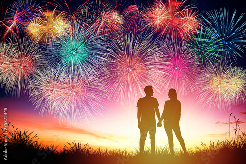 young couple watching fireworks on hill © Tom Wang