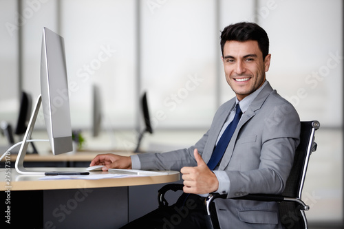Photos Businessman using computer and thump up..