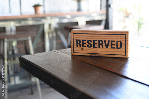 Restaurant reserved table sign Reserved Table. A tag of reservation placed on the wood table