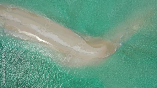 Waves dashing on the shores of a small white sand island in the tropical waters of Thailand photo