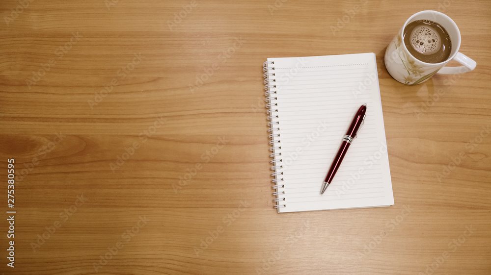 cup of coffee and notebook on a table cup of coffee and notebook on a table