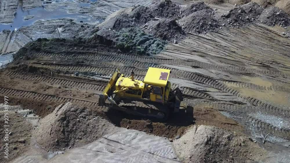 Circling shot of old Bulldozer pushing dirt on a construction site Circling shot of old Bulldozer pushing dirt on a construction site