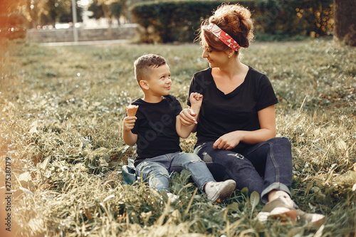 Family in a summer park. Mother in a black t-shirt. Cute little boy with ice cream