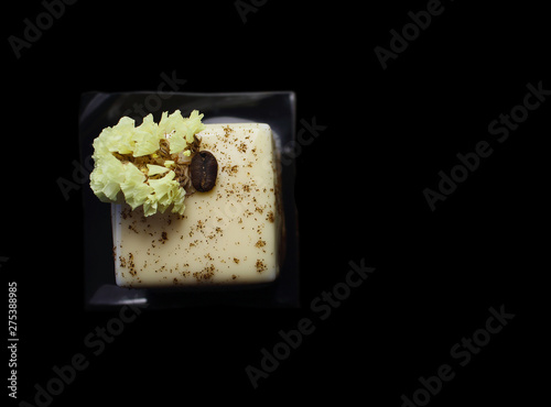 Coffee cube dessert with coffee bean and spring flower flat lay isolated on black background