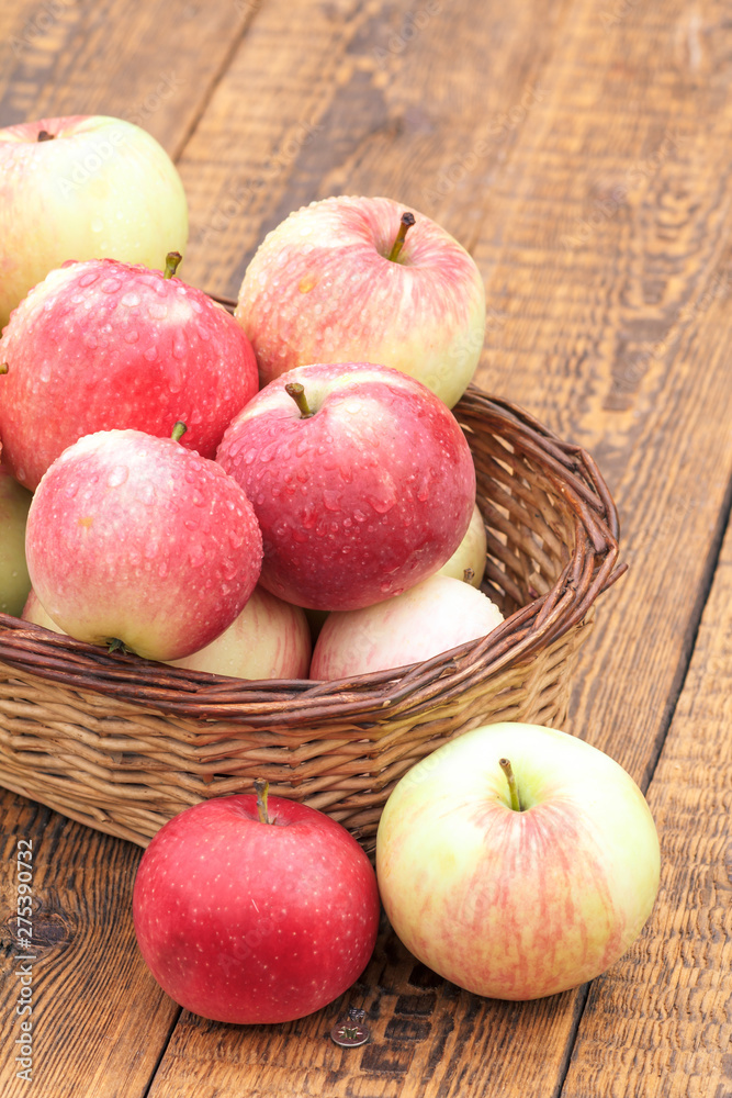 Red apples in wicker basket on wooden boards Red apples in wicker basket on wooden boards