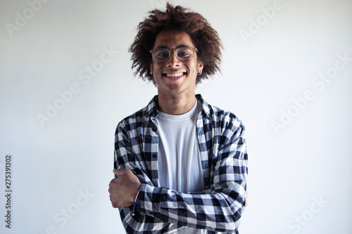 Handsome young african american man smiling while looking at camera over white background.