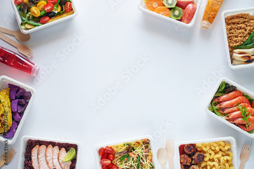 Prepared meal delivery concept with copy space. Top view of assorted ready-to-eat dishes over white background: seafood, meat, pasta, noodles, quinoa, veggies and fruits. photo