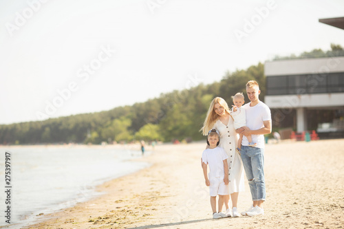 Smiling parents with children at sea. Happy family with two children enjoying summer holiday at beach in Estonia, Tallinn