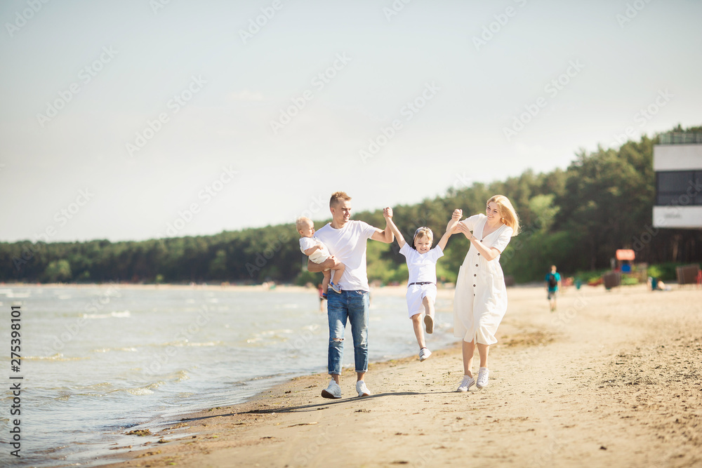 Smiling parents with children at sea. Happy family with two children enjoying summer holiday at beach in Estonia, Tallinn