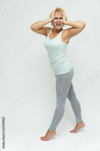 Full-length portrait of a slim beautiful pretty girl blonde woman with short curly hair on a white background in light lingerie standing right in various poses shows fitness and a lot of emotions.