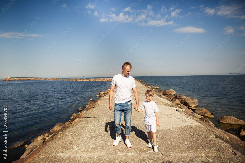 Happy father and son walking on the pier in a sunny day. Estonia, Tallinn