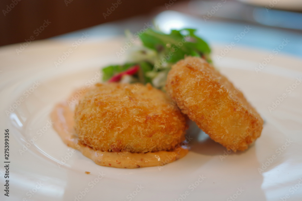 Delicious croquettes potato beef meat korokke with sauce in white plate decorated with vegetable Delicious croquettes potato beef meat korokke with sauce in white plate decorated with vegetable
