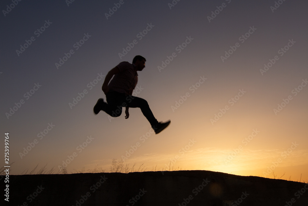 silhouette of man jumping at sunrise