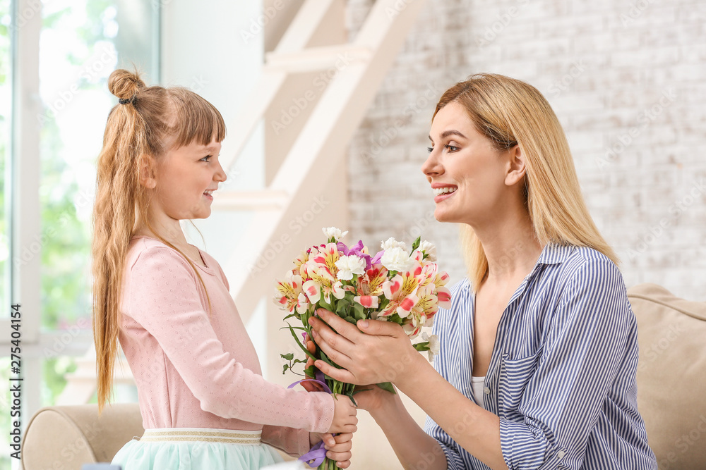 Little girl greeting her mother with bouquet of flowers at home Little girl greeting her mother with bouquet of flowers at home