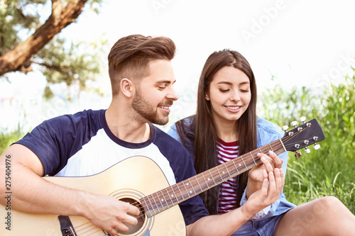 Young couple with guitar on picnic in park