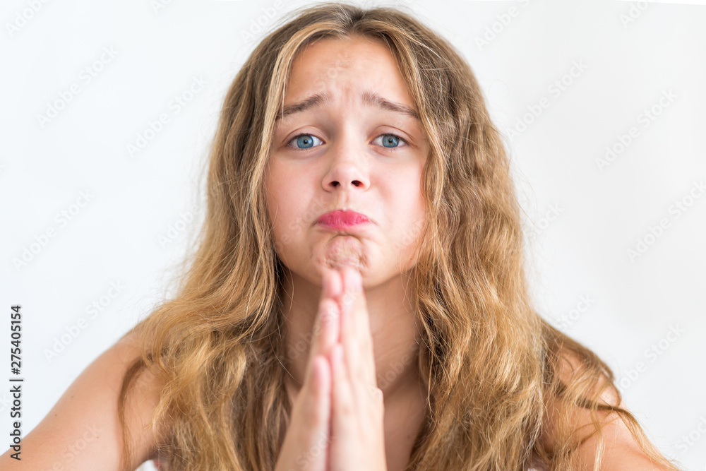 Regretful girl looks gloomy and desperate, keeps palms together, beggs for forgiveness, feels sorry and guilty. Cute adorable girl pleads about something Regretful girl looks gloomy and desperate, keeps palms together, beggs for forgiveness, feels sorry and guilty. Cute adorable girl pleads about something