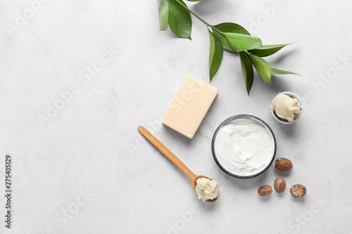Shea butter with cream and soap on light background
