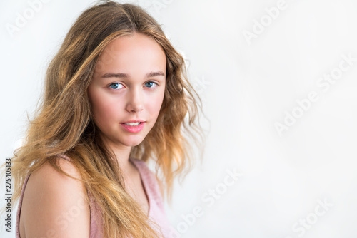 portrait of a beautiful young blonde smiling girl with long hair on a white background
