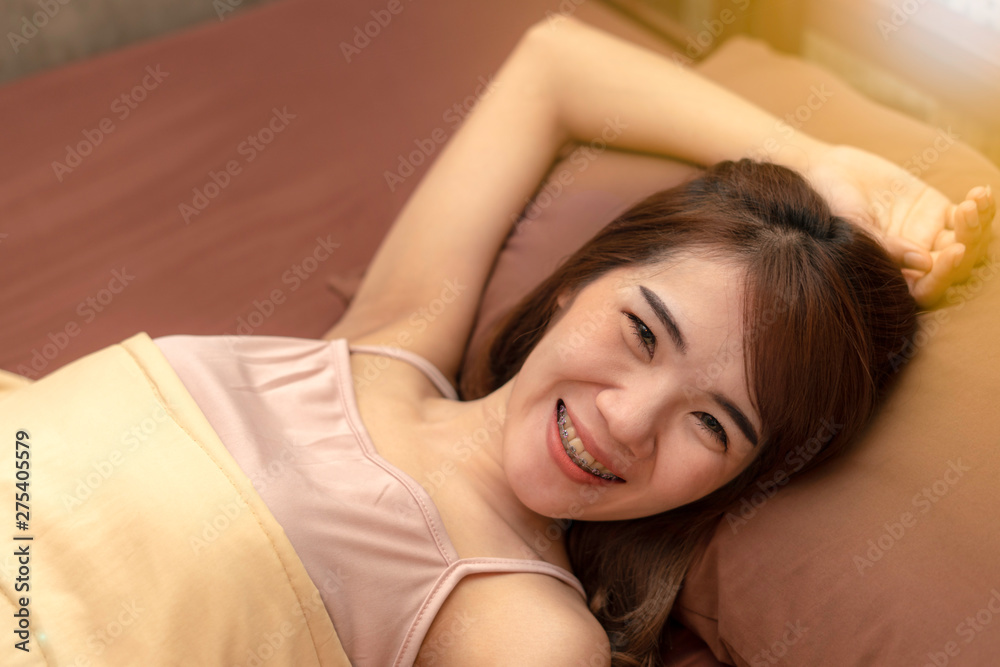 Women smile, happy and lie on the bed after waking up in the morning. Enough rest. Women smile, happy and lie on the bed after waking up in the morning. Enough rest.