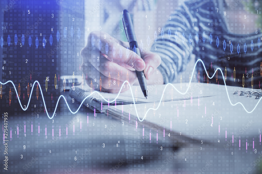 Financial forex graph drawn over hands taking notes background. Concept of research. Double exposure