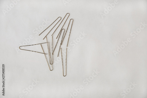 Silver metal hairpins are in random order on a white background on the left side