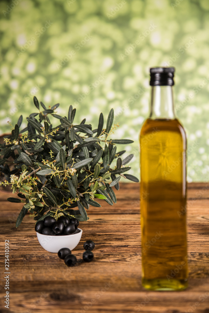 Olive tree and bottles with oil, olives on a wood table. Olive tree and bottles with oil, olives on a wood table.