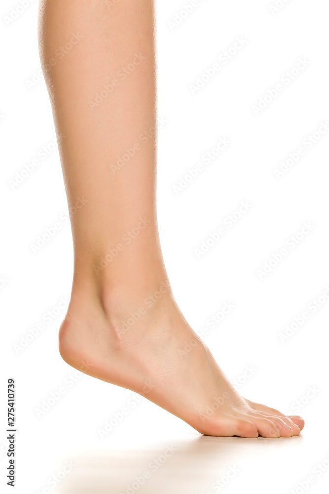 Side view of female bare foot in three different positions on white background
