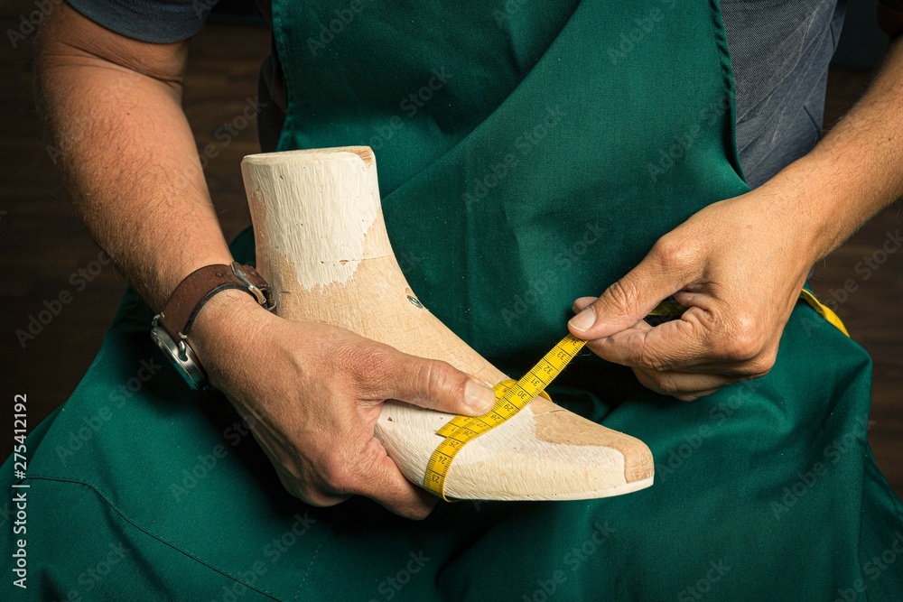 close up of orthopedic shoemaker measuring a wooden last - obrazy, fototapety, plakaty 