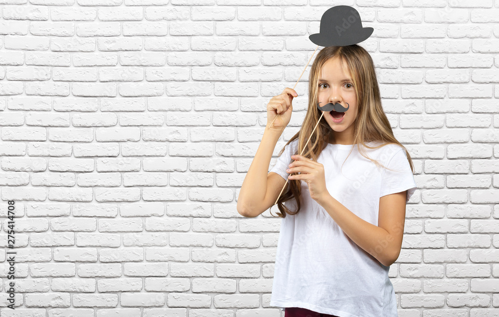 Lovely little girl in a with funny photo props paper. Happy kid Lovely little girl in a with funny photo props paper. Happy kid