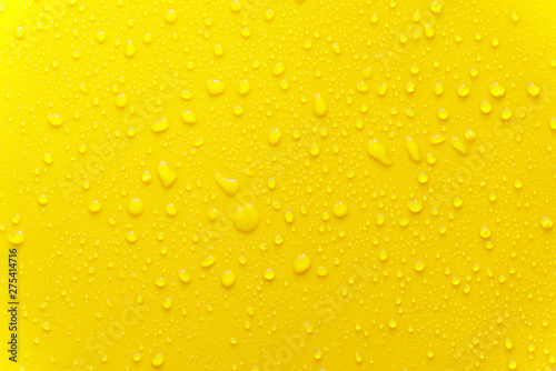 water drop texture close-up on yellow matte background.