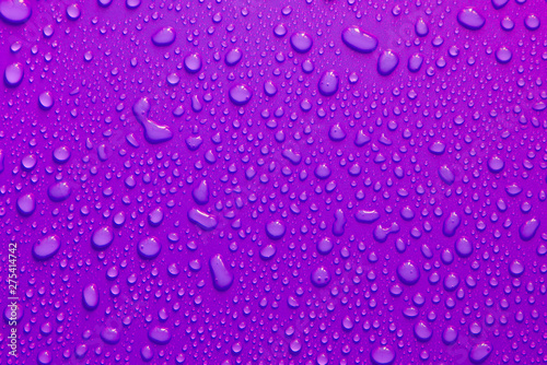 water drop texture close-up on purple matte background.