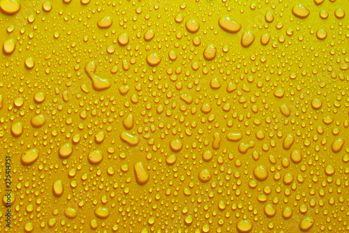 water drop texture close-up on yellow matte background.