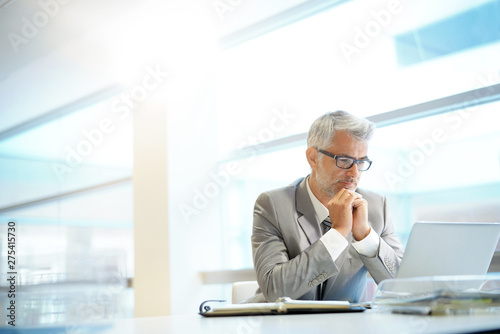 Stylish businessman working at desk in contemporary office
