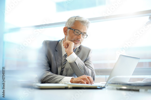 Stylish businessman working at desk in contemporary office