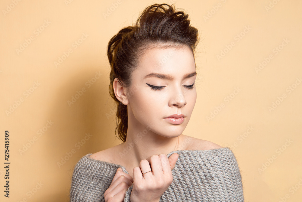 Young beautiful girl with dark hair with a hairstyle a high bunch of makeup, even skin tone with a black arrow and sparkles on her lips Young beautiful girl with dark hair with a hairstyle a high bunch of makeup, even skin tone with a black arrow and sparkles on her lips