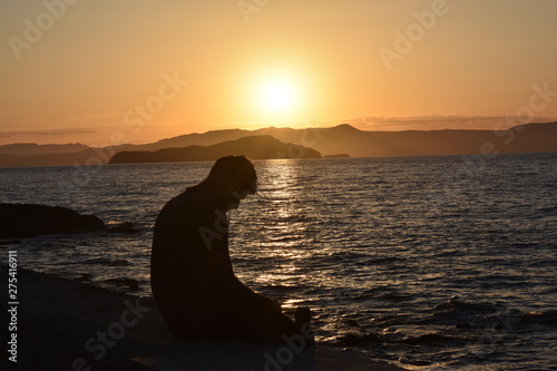 Man silhouette and sunset in Crete, Greece