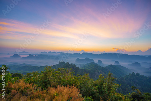 Beautiful mountain range with sky blue and orange light of the sun through the clouds in the sky  Background sky during Sunrise with fog on mountain  Abundant lush forest-Image